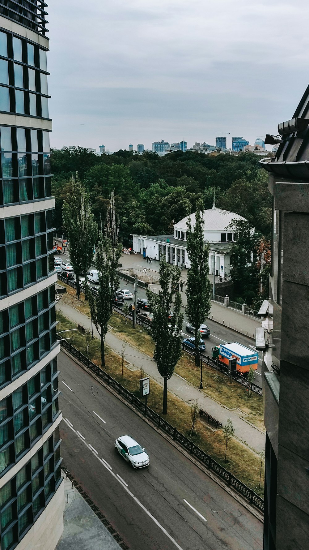 a car driving down a street next to a tall building