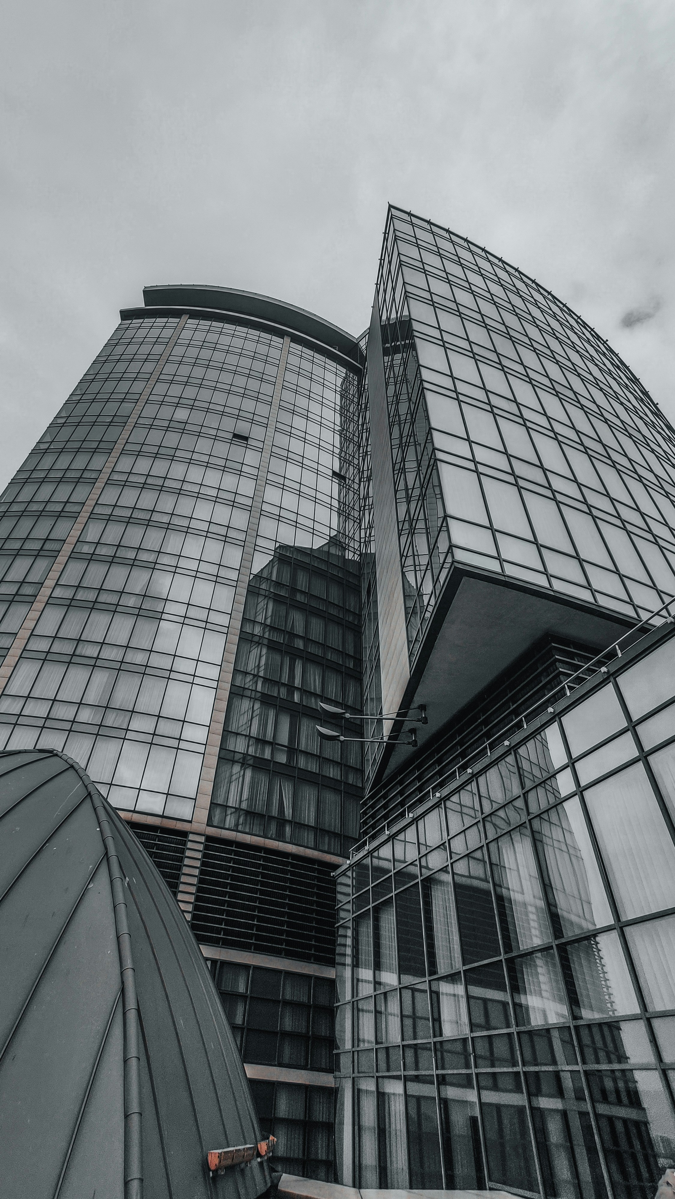 Modern glass skyscraper reflecting sky, architectural photography, urban real estate, deep blue tones, dark atmospheric city