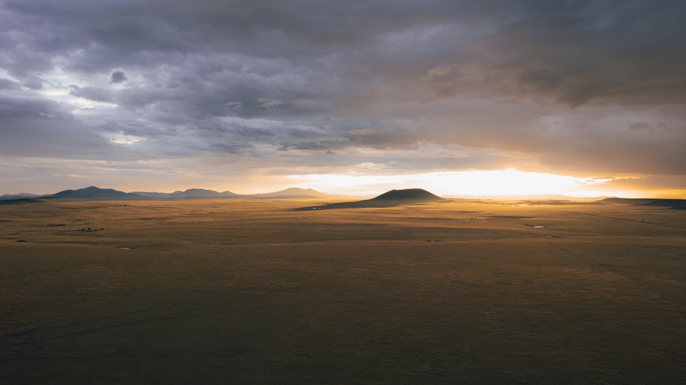 the sun is setting over the mountains in the desert