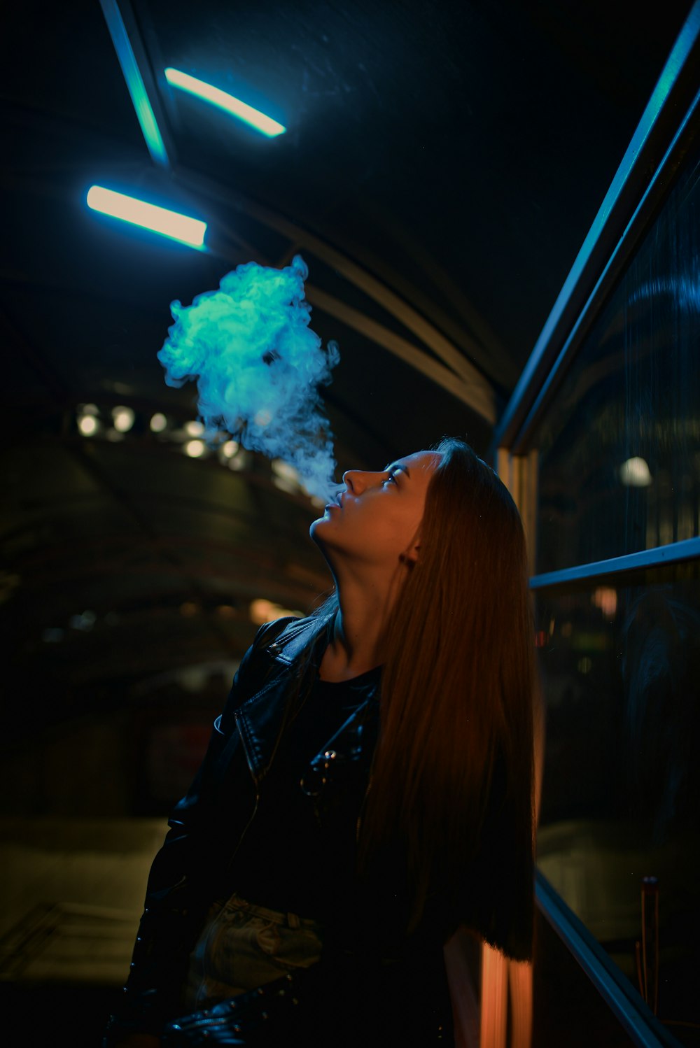 a woman smoking a cigarette in a dark room