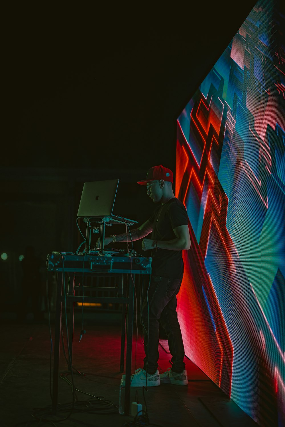 a man standing in front of a large screen