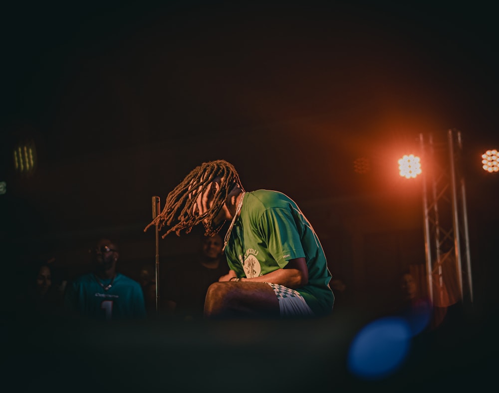 a man with dreadlocks sitting in front of a microphone