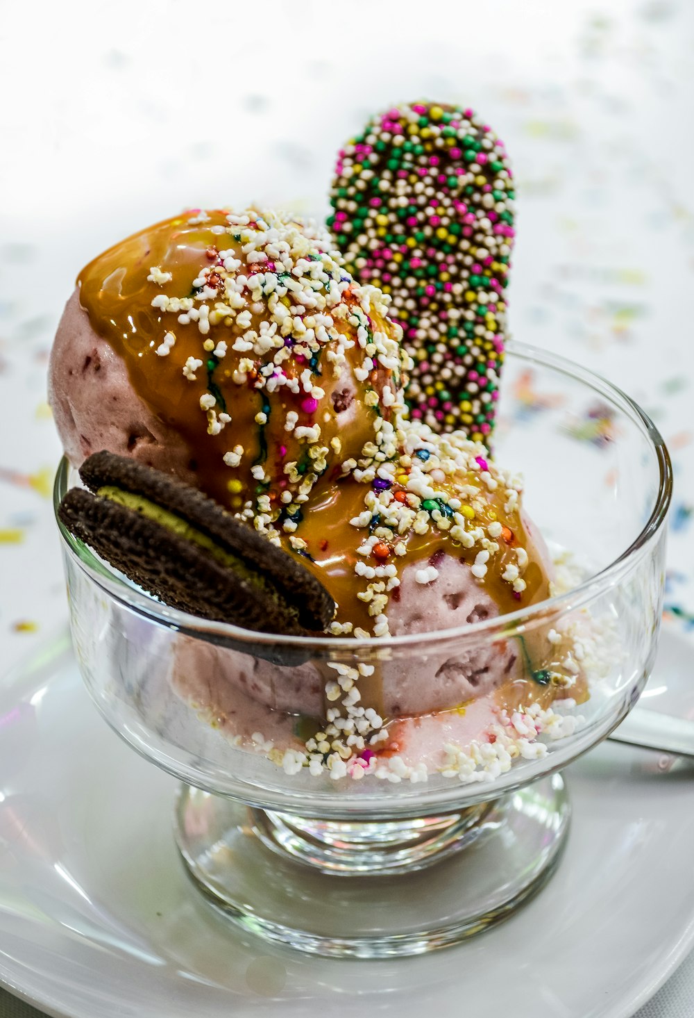 an ice cream sundae with sprinkles and a cookie