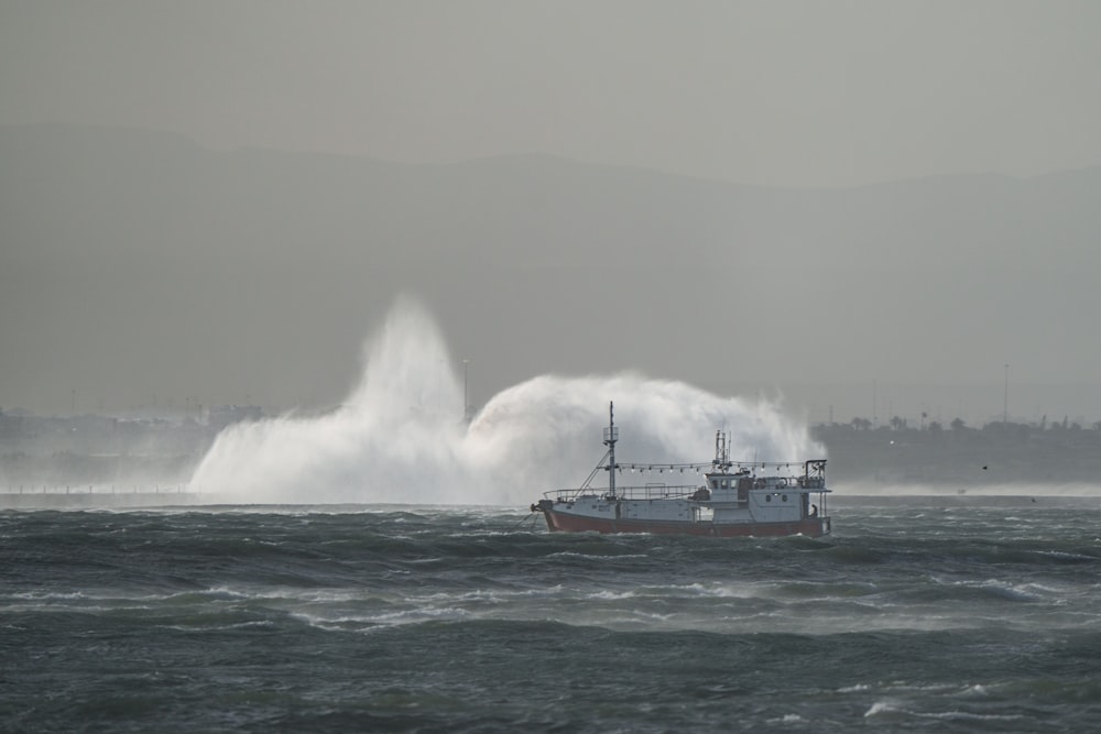 a boat in the water with a huge wave in the background