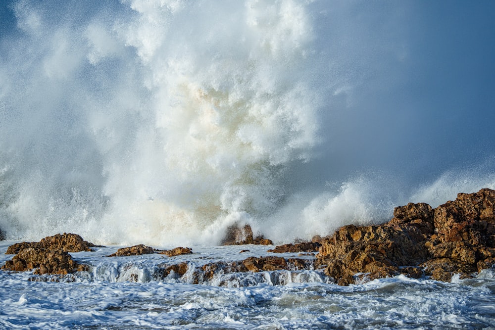 Una grande onda che si infrange sulle rocce nell'oceano