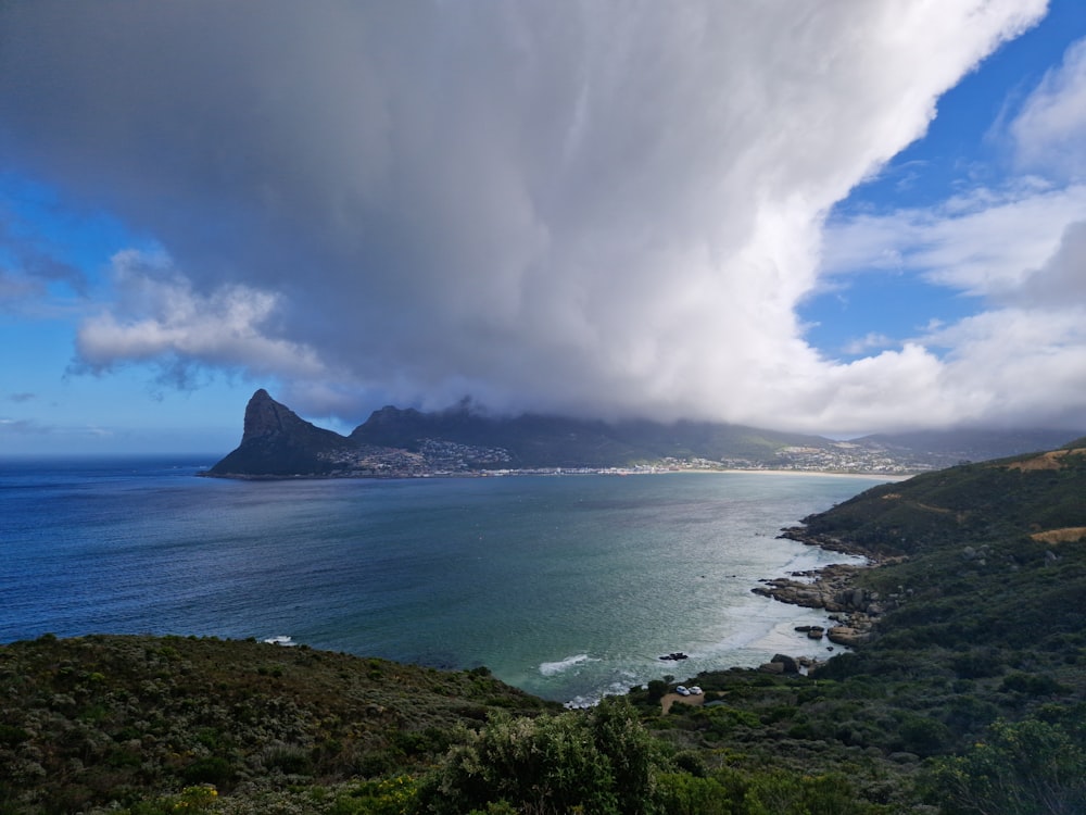 a large body of water with a mountain in the background