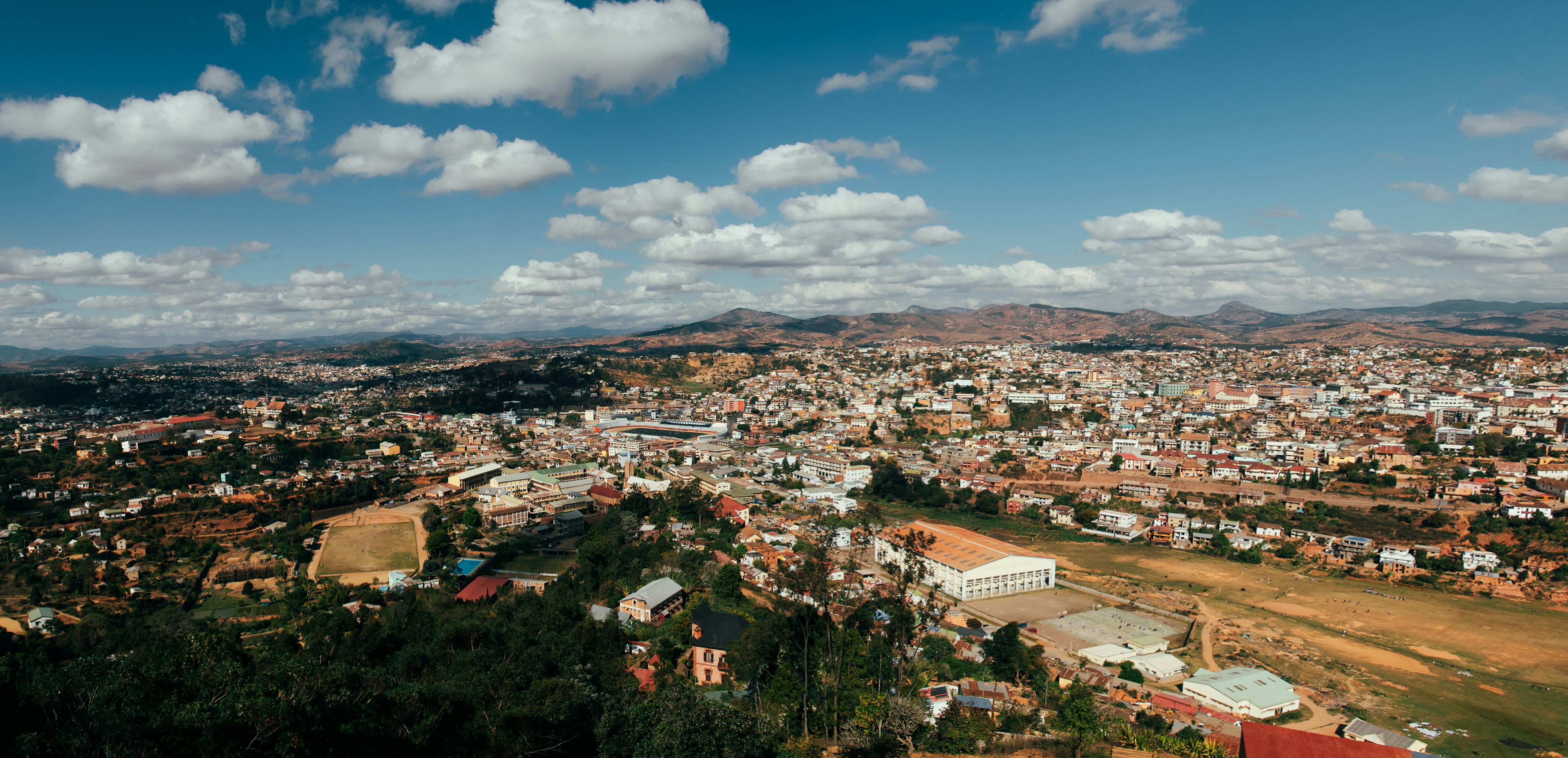 an aerial view of a city with mountains in the background
