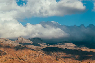 a view of a mountain range with clouds in the sky