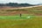 A smiling farmer standing in a lush green field.