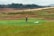 A smiling farmer standing in a lush green field.