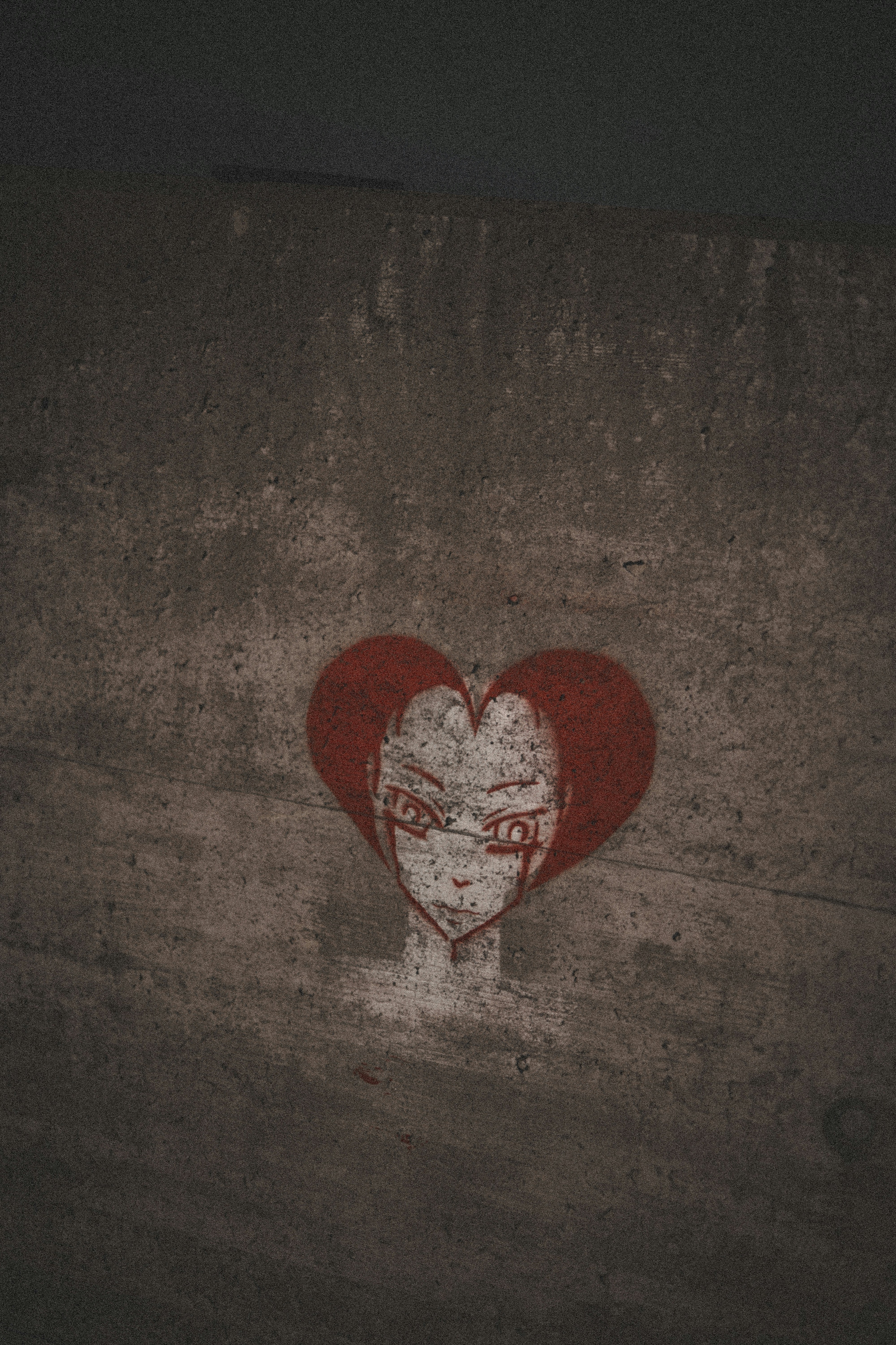 a red heart painted on the side of a concrete wall