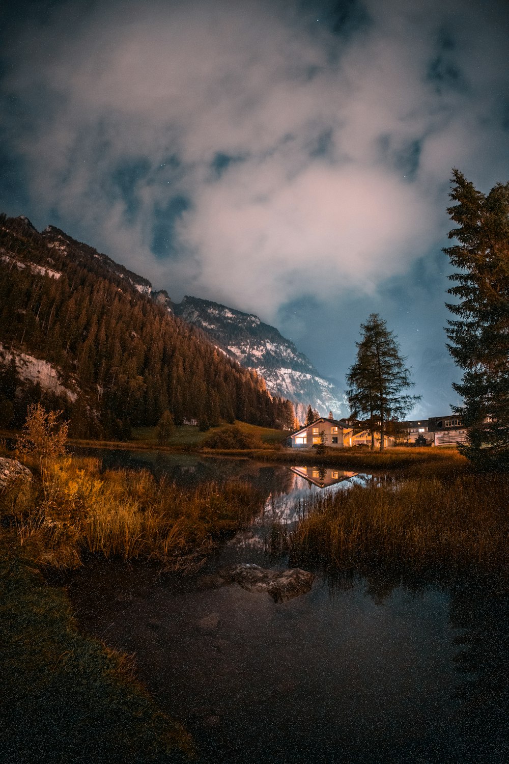 a lake surrounded by trees and a mountain in the background