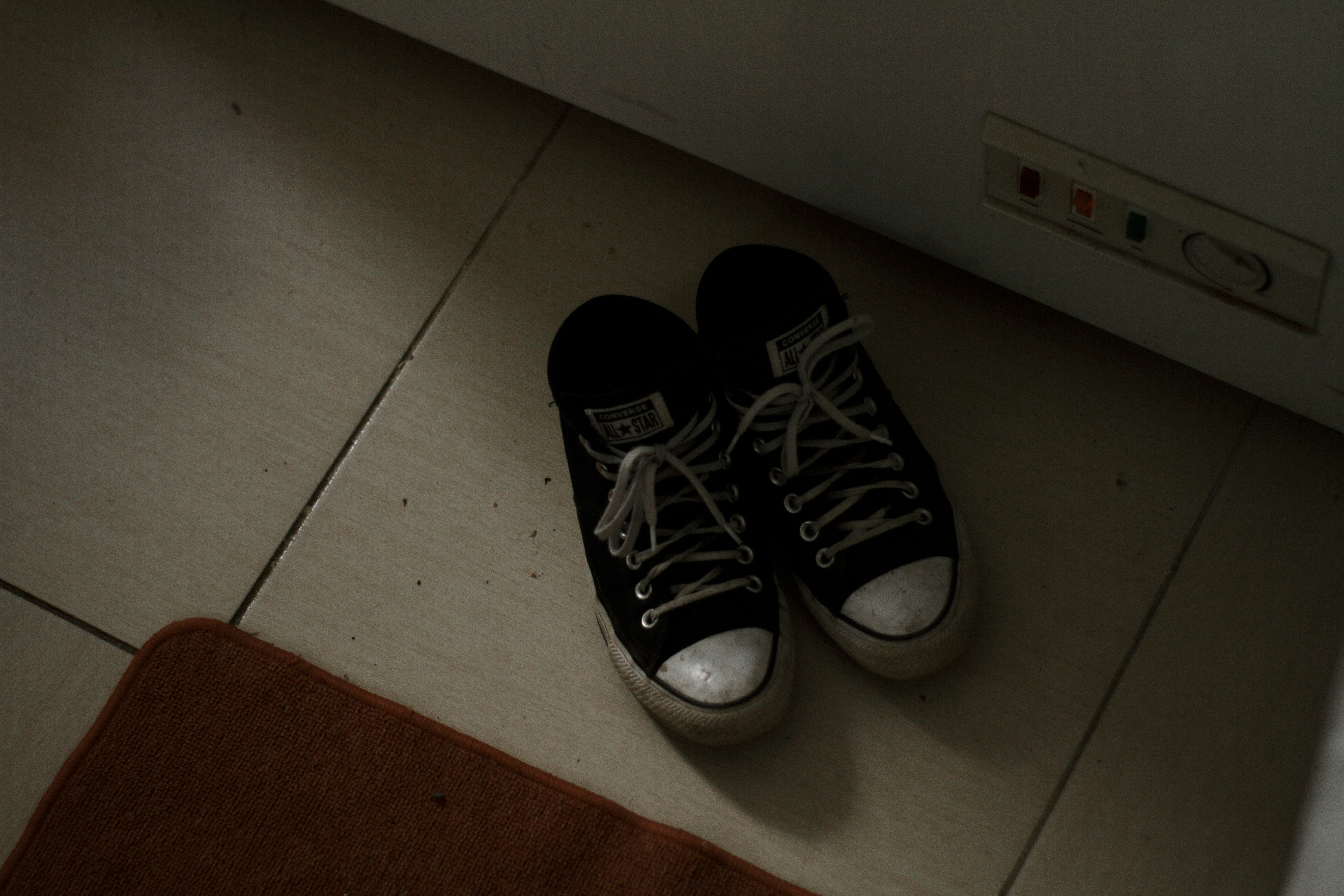 a pair of black and white tennis shoes on the floor