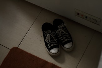 a pair of black and white tennis shoes on the floor