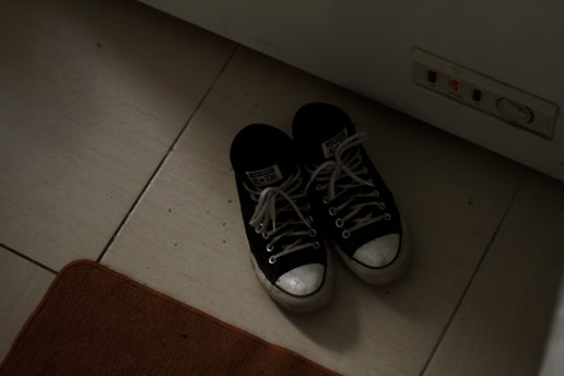 a pair of black and white tennis shoes on the floor