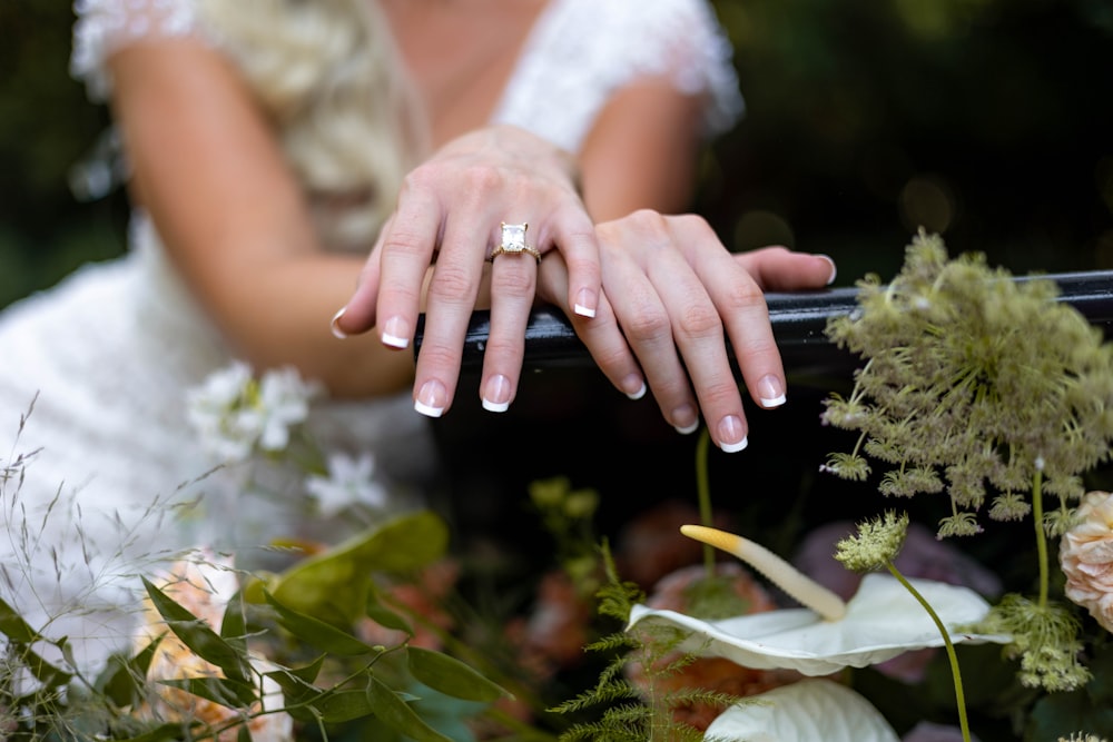 a bride and groom holding hands in front of flowers