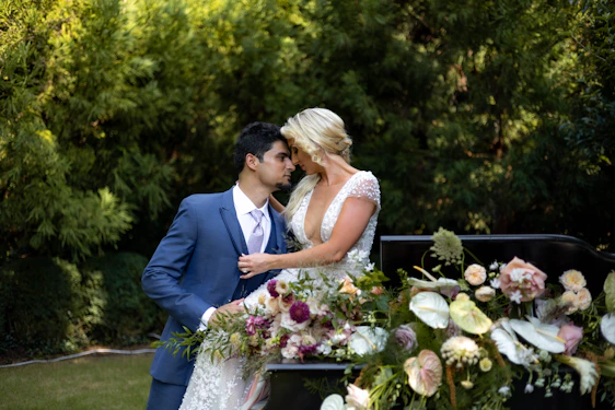 A romantic couple exchanging vows under soft white floral decorations with a royal blue and silver theme.
