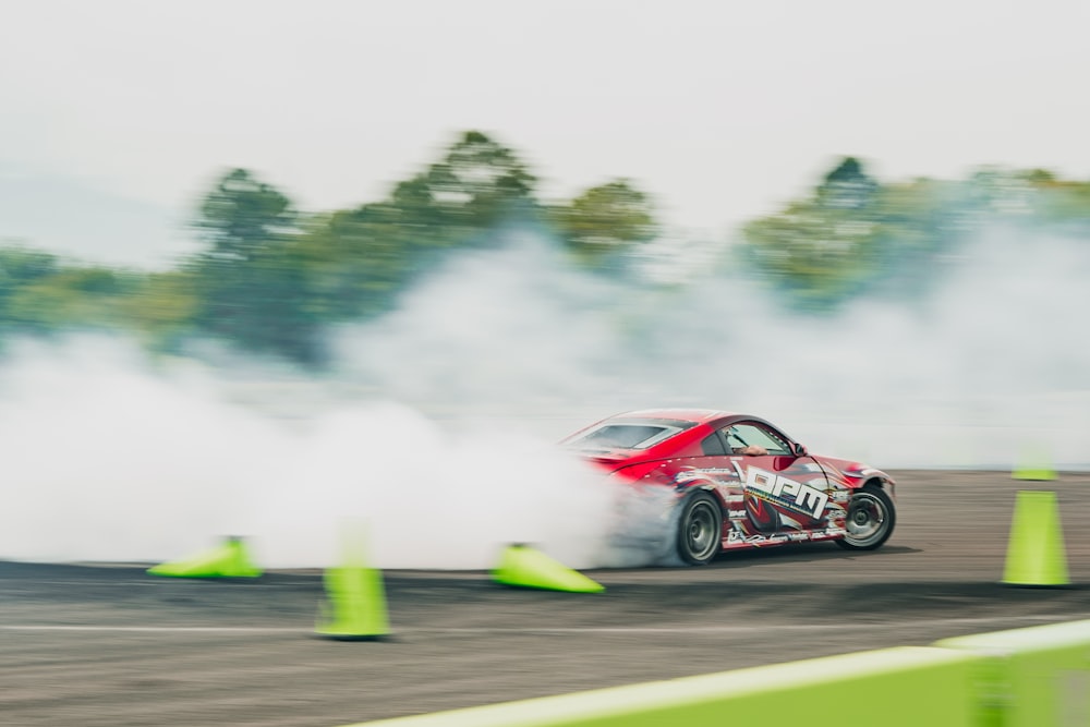 a car driving around a track with a lot of smoke coming out of it
