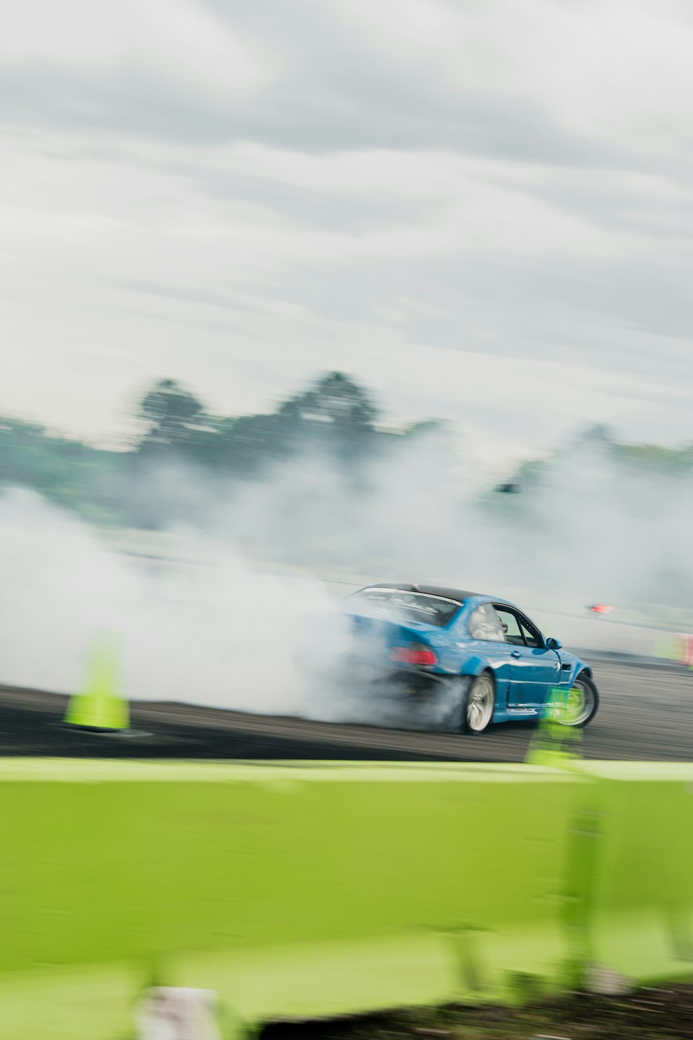 a blue car driving down a race track