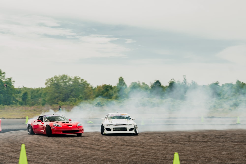 a couple of cars driving down a dirt road