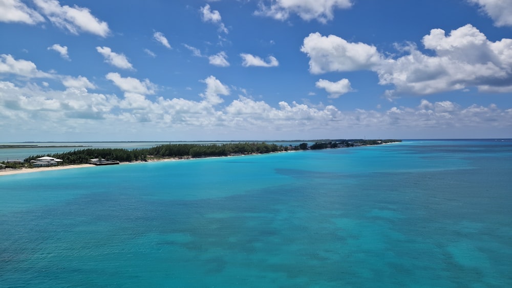 a long stretch of blue water with a beach in the background