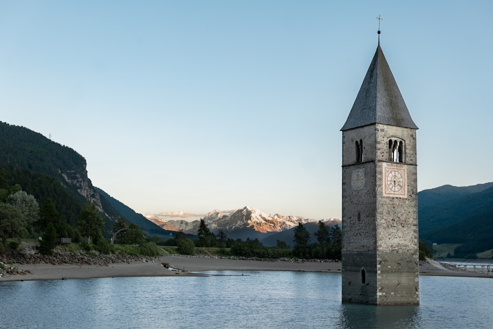 Una torre dell'orologio seduta nel mezzo di un lago
