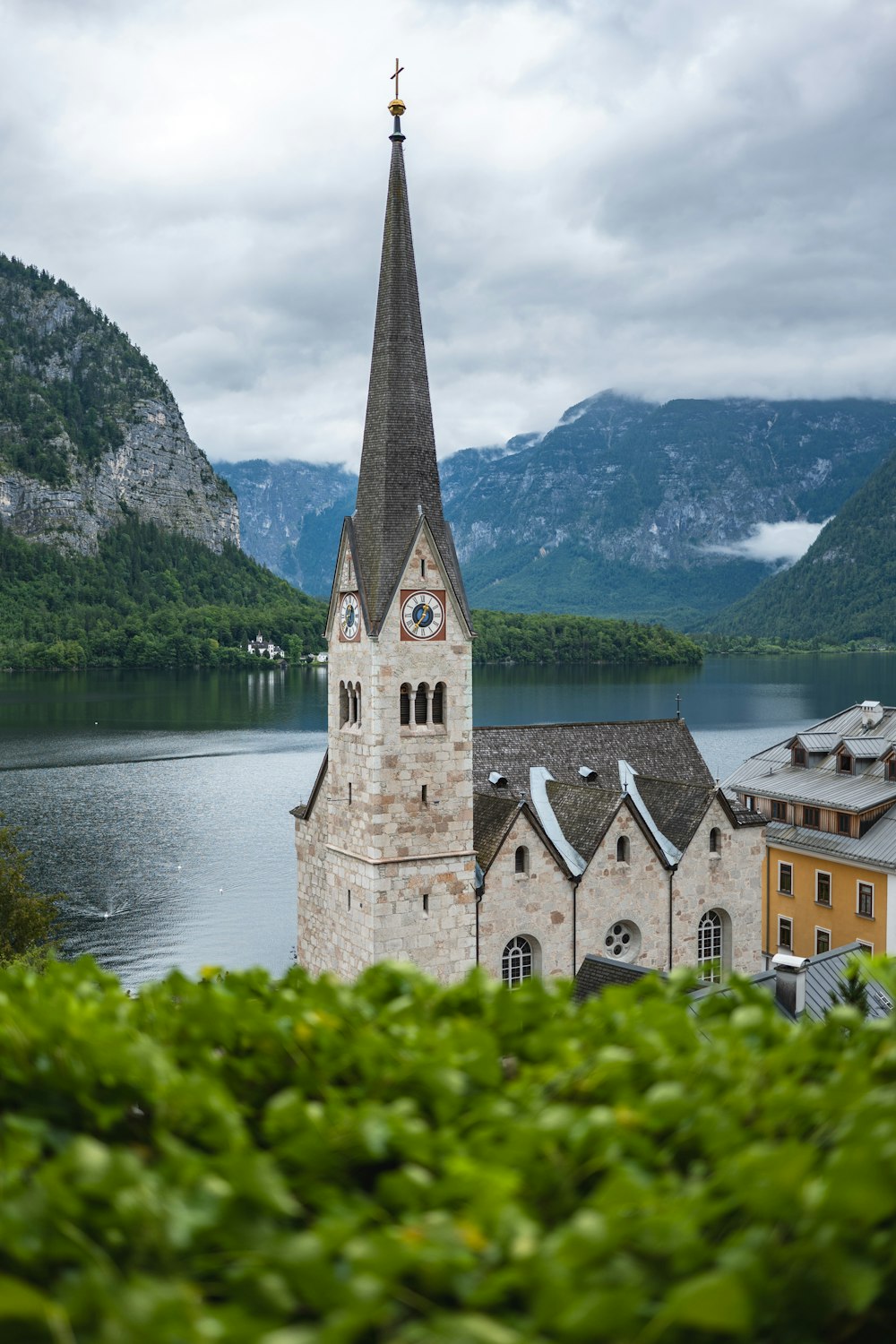 a church with a steeple next to a body of water