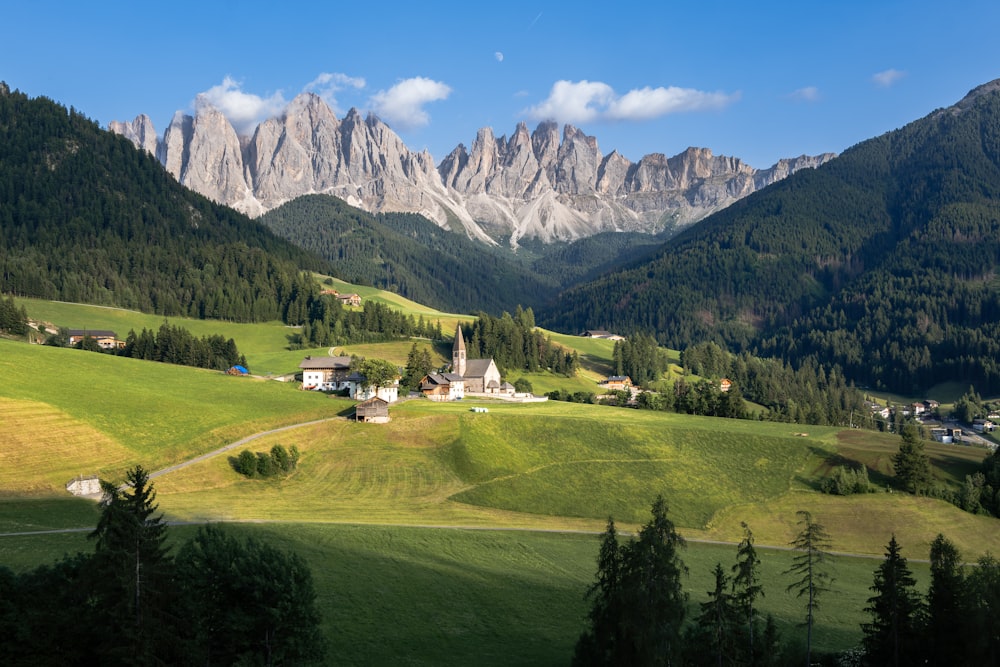 a scenic view of a mountain range with a church in the foreground