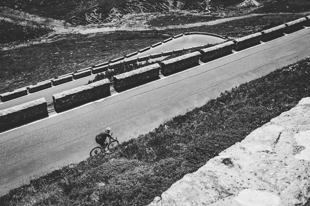 uma foto em preto e branco de uma pessoa andando de bicicleta