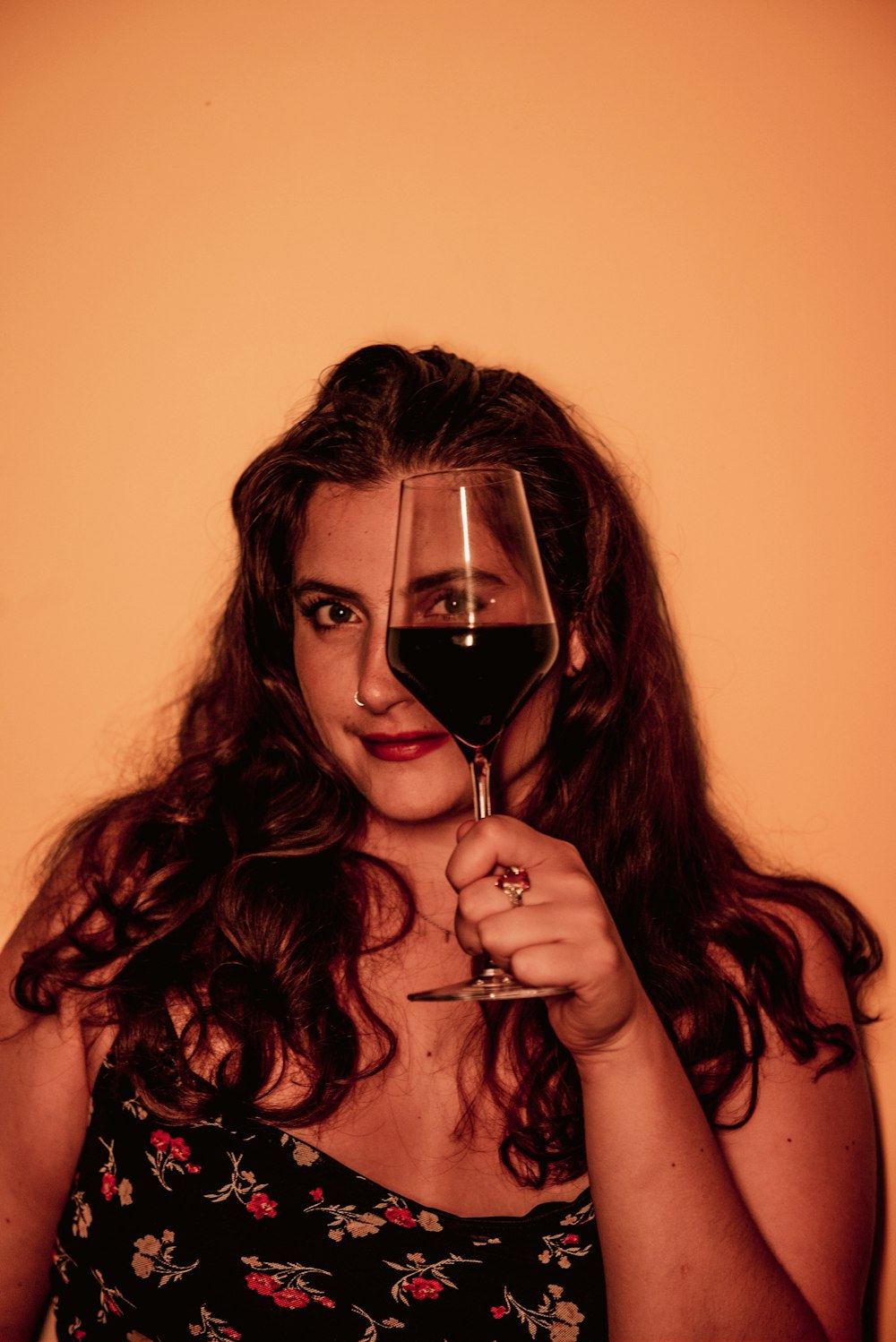 a woman holding a glass of wine in front of her face