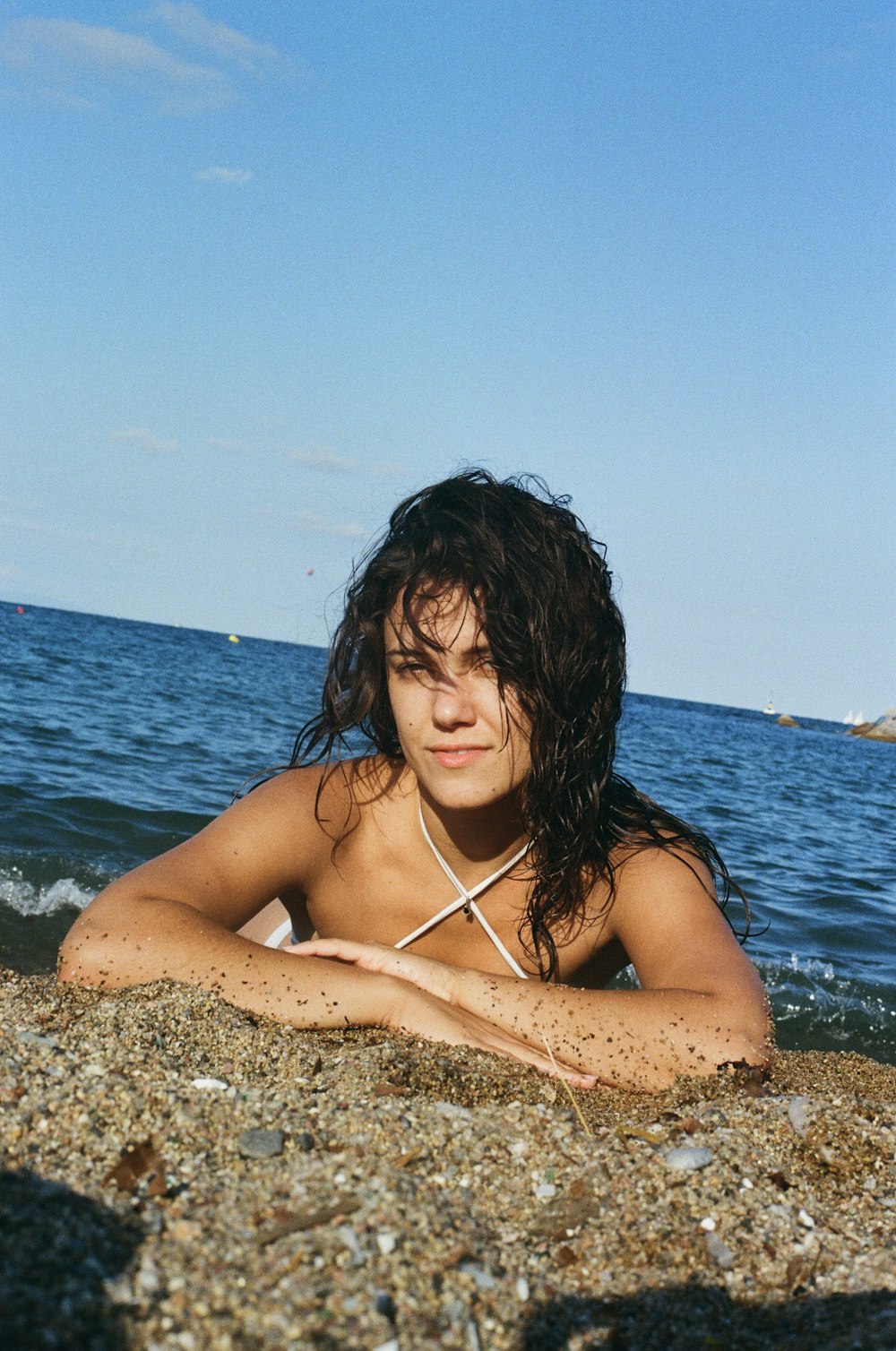 a woman in a bikini laying on the beach