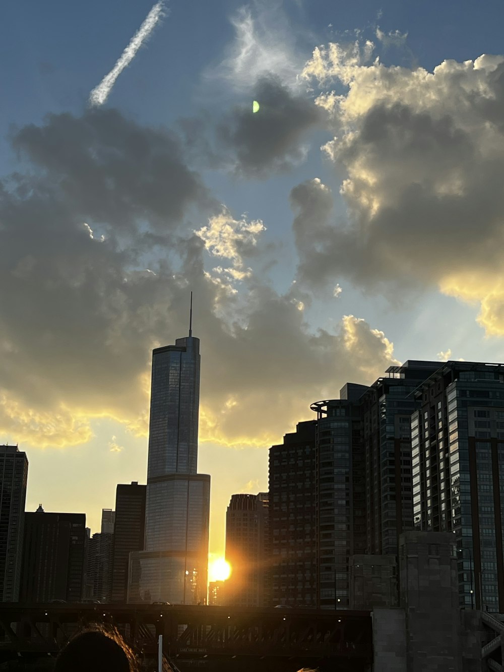 the sun is setting over a city with tall buildings