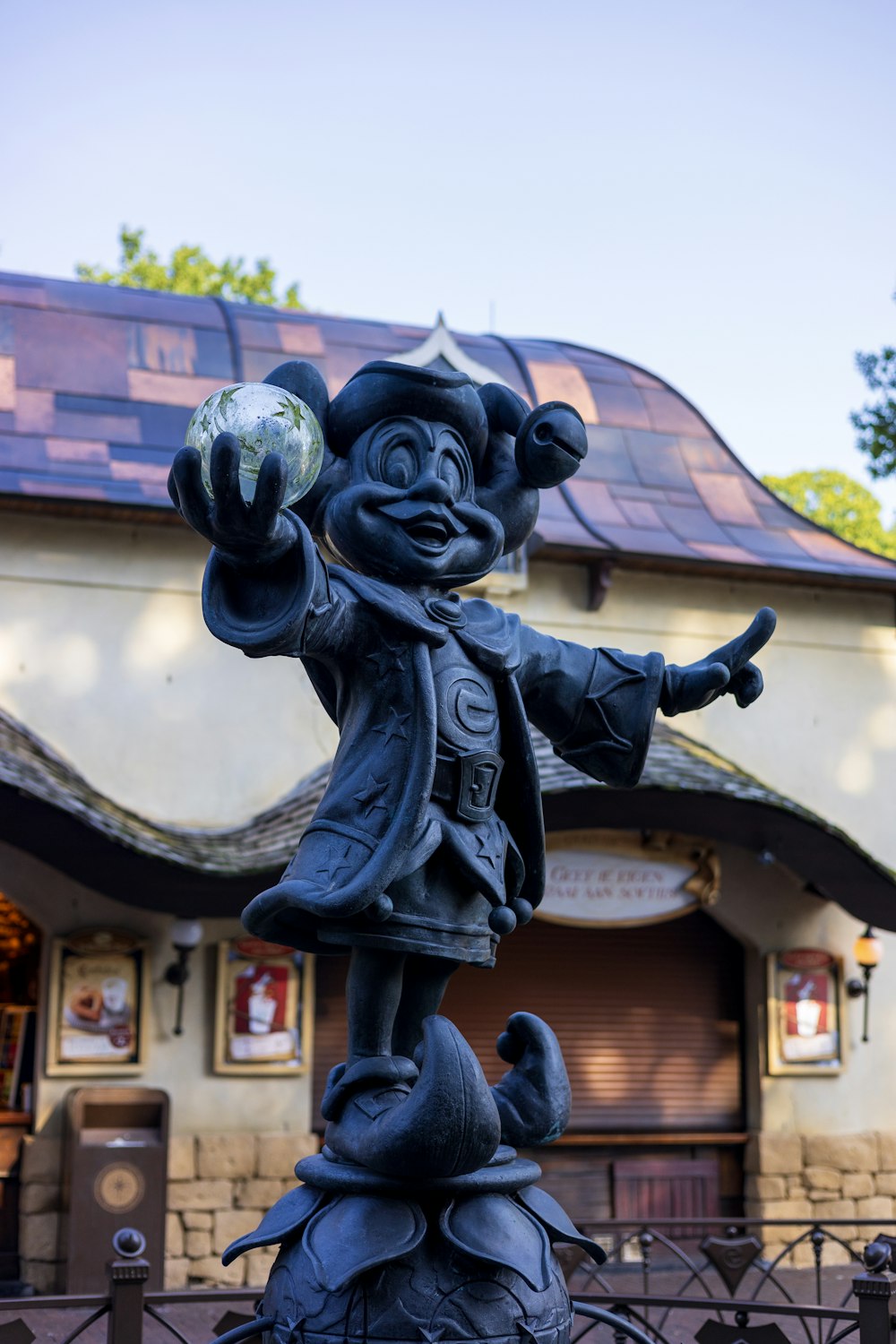 a statue of a person holding a ball in front of a building