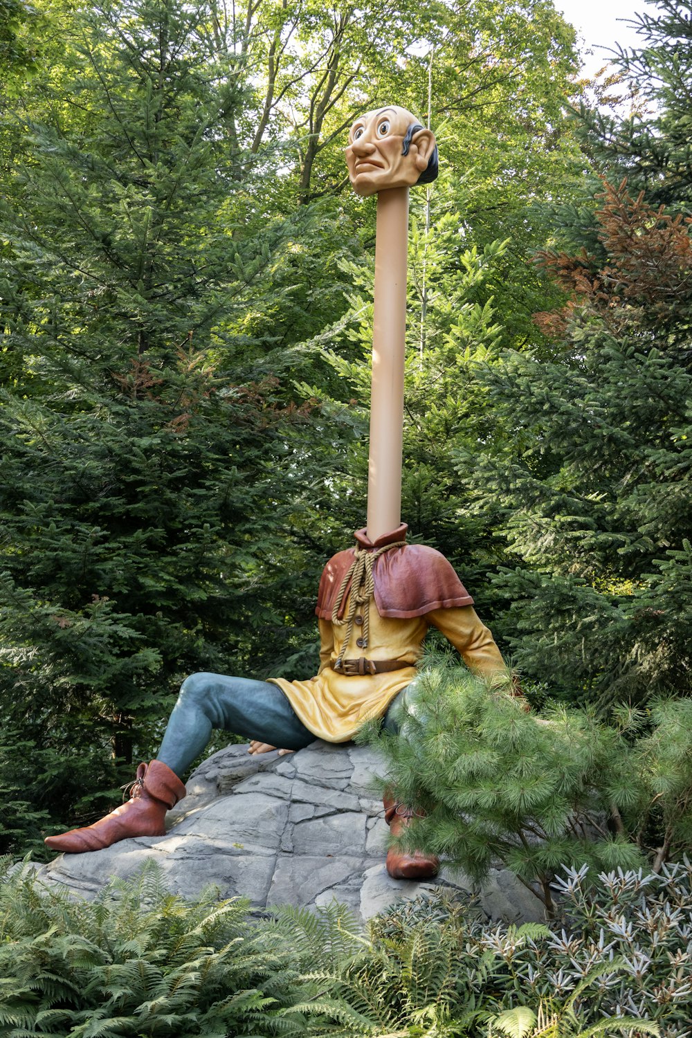 una statua di un uomo seduto sulla cima di una roccia