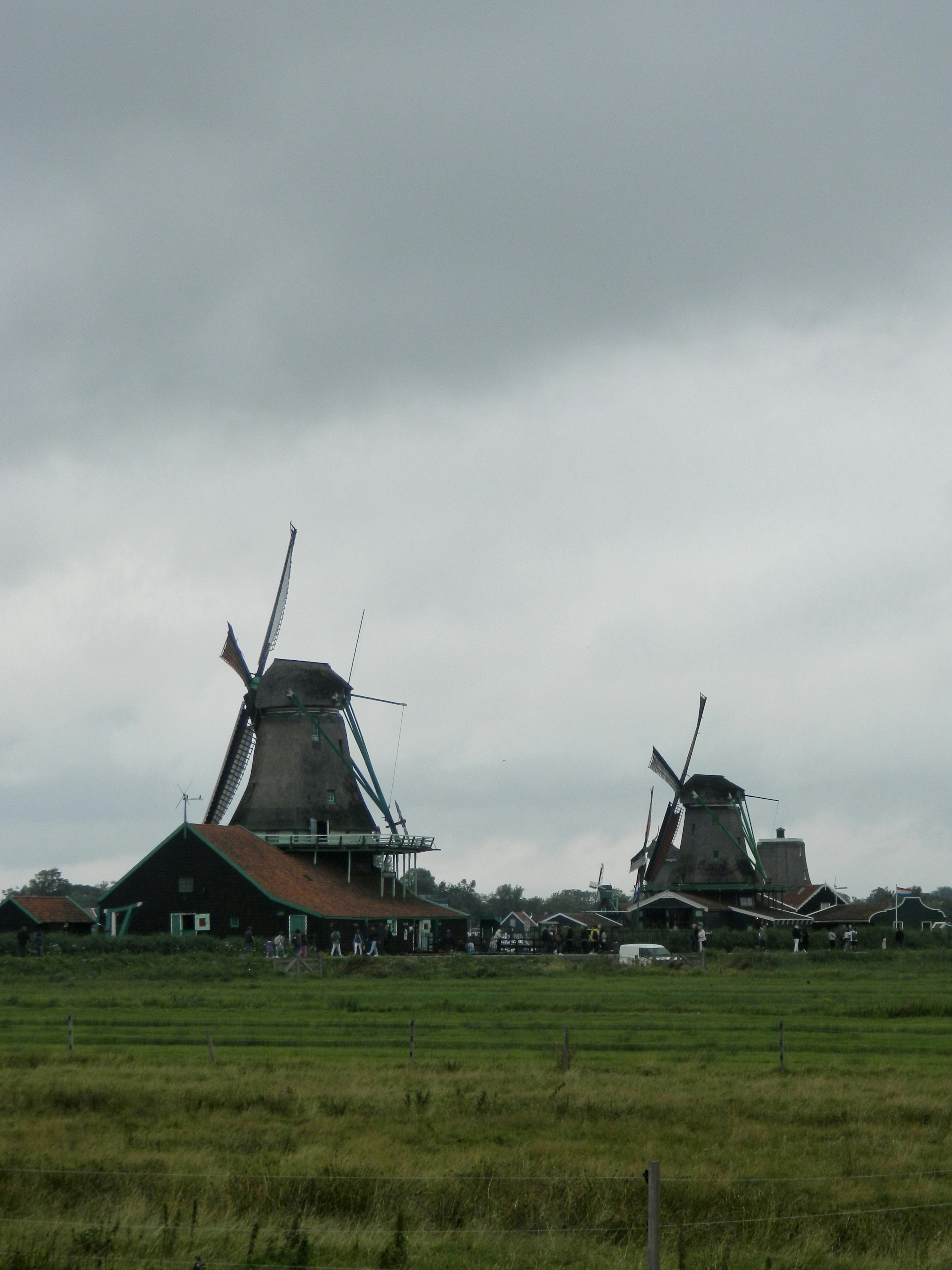 a couple of windmills sitting on top of a lush green field