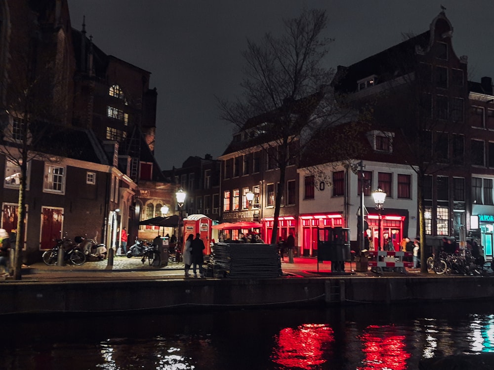 a group of people walking down a street next to a body of water