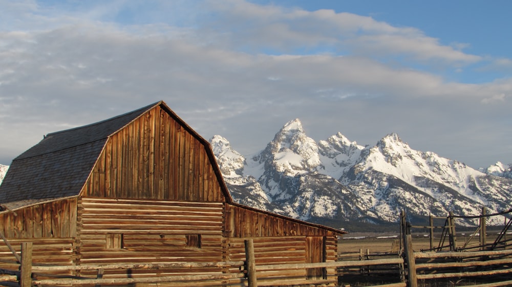 a barn in front of a mountain range