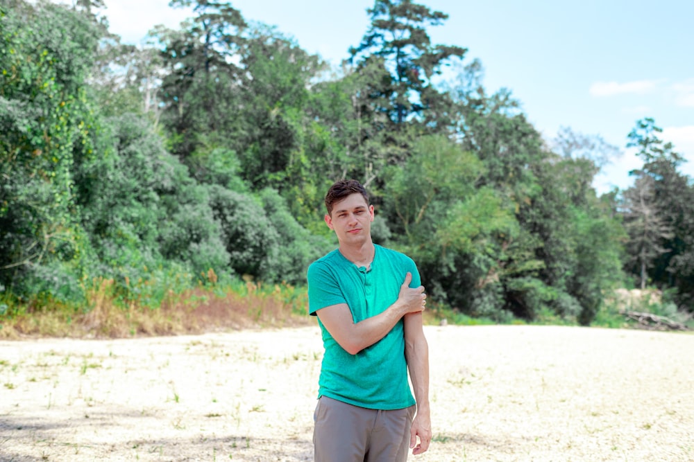 a man in a green shirt standing in a field