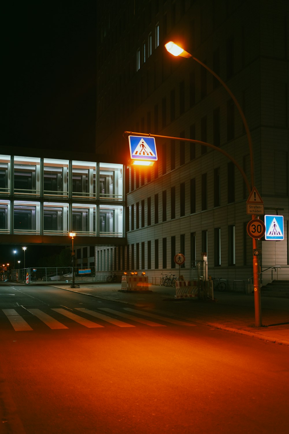 a street at night with a traffic light and a building in the background