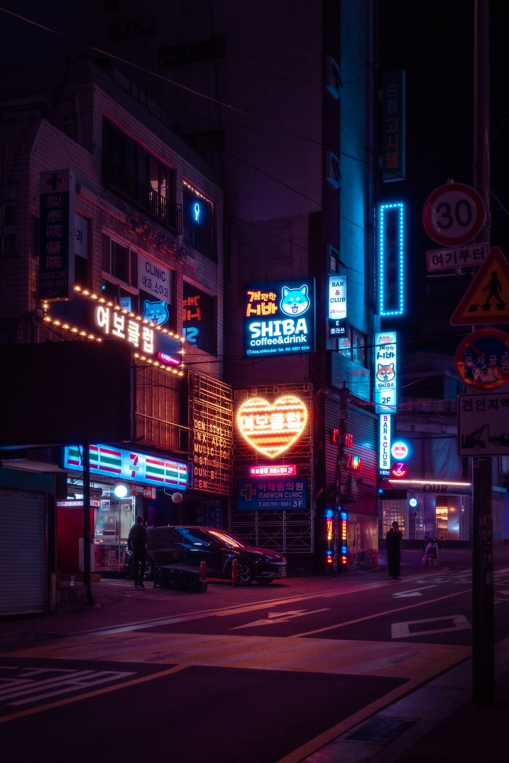 a city street at night with neon signs