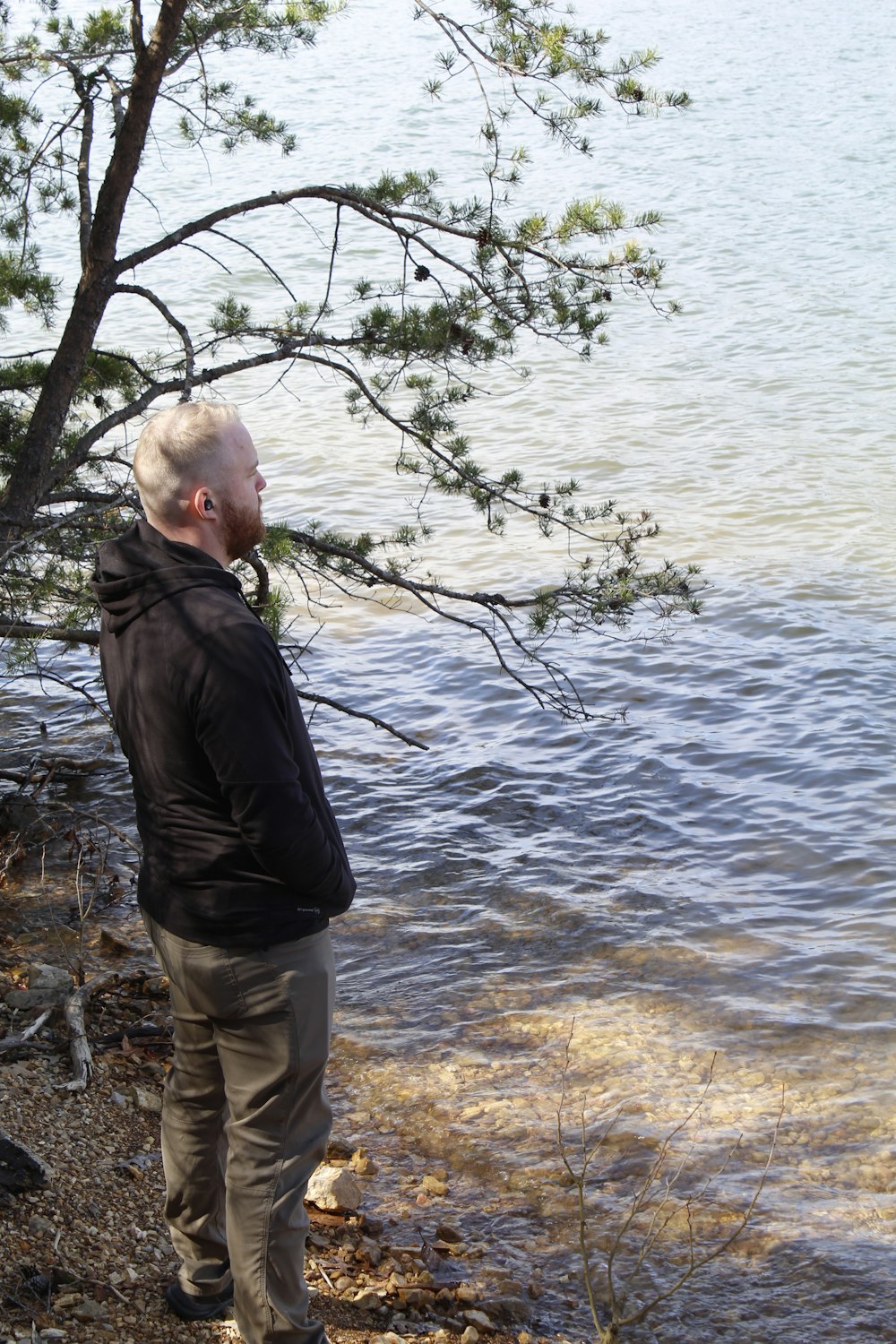 a man standing next to a body of water