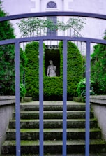 a blue gate with a statue in the middle of it