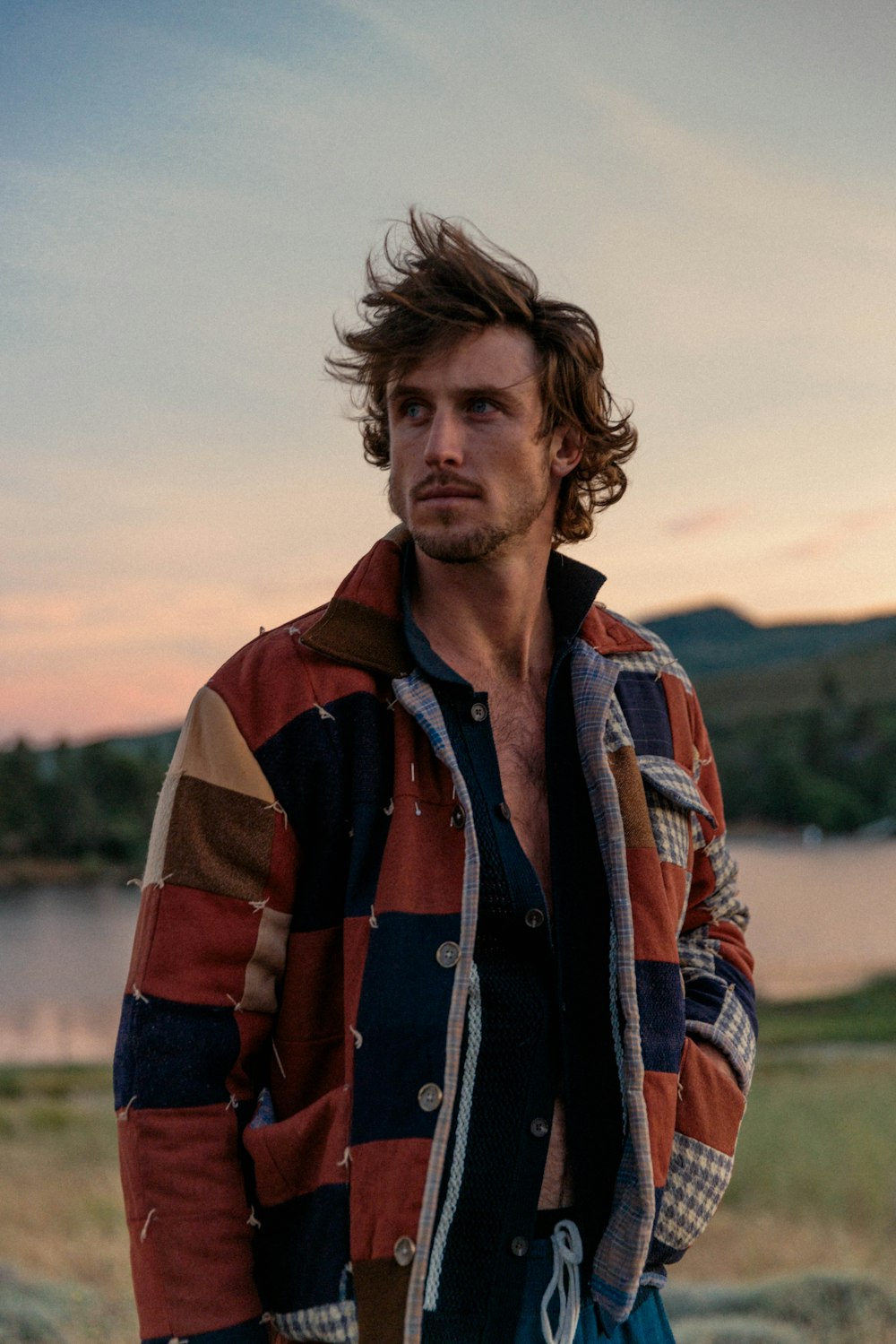 a man standing in front of a body of water