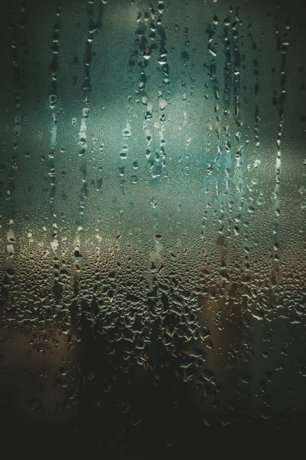 gotas de chuva em uma janela com um fundo escuro