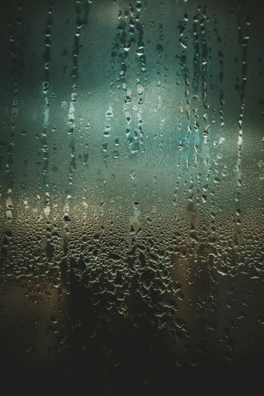 rain drops on a window with a dark background