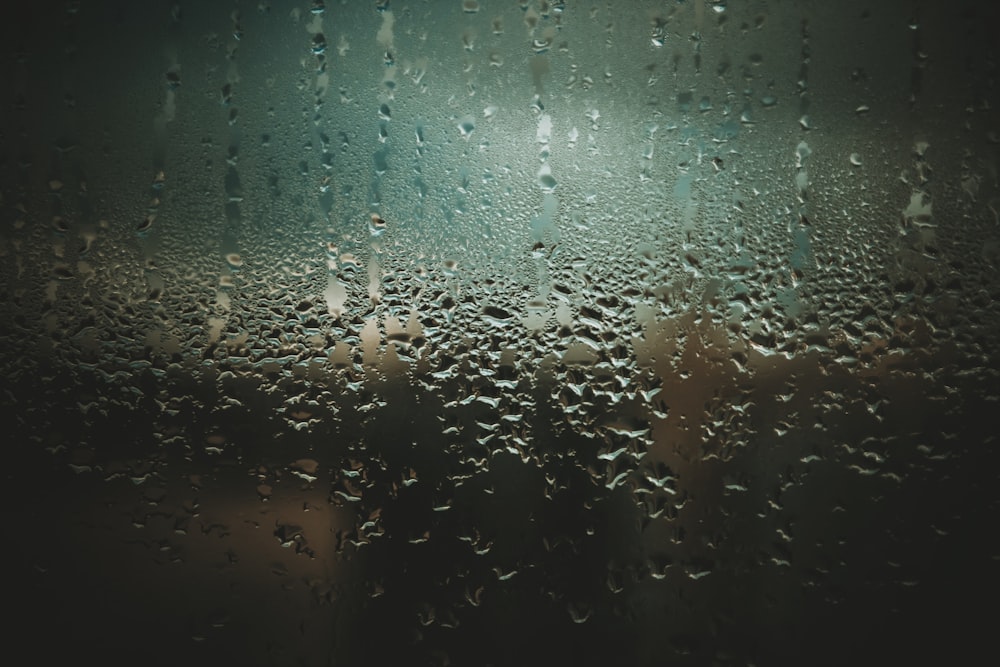 Regentropfen auf einem Fenster mit verschwommenem Hintergrund