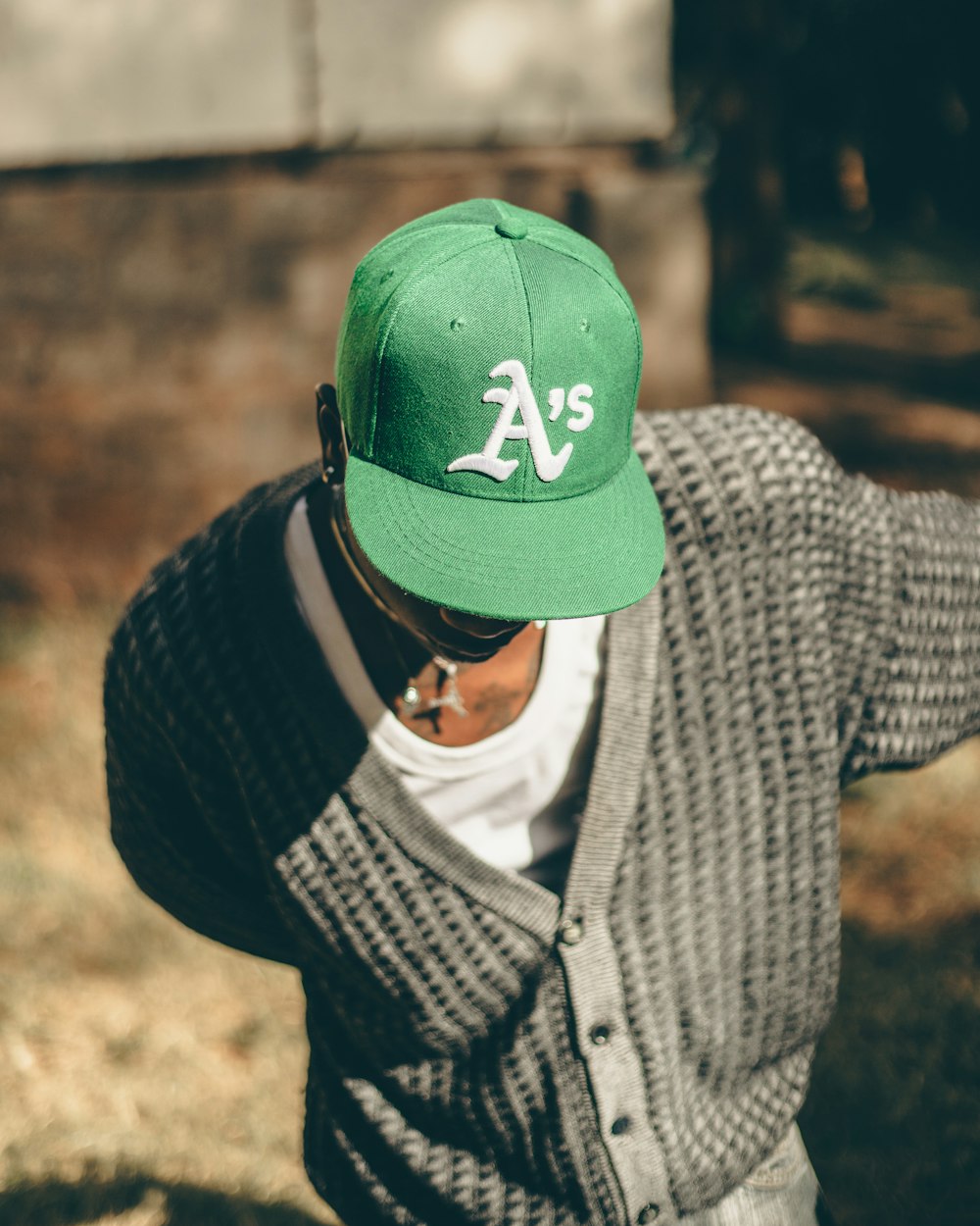 a man wearing a green hat with a white a's on it