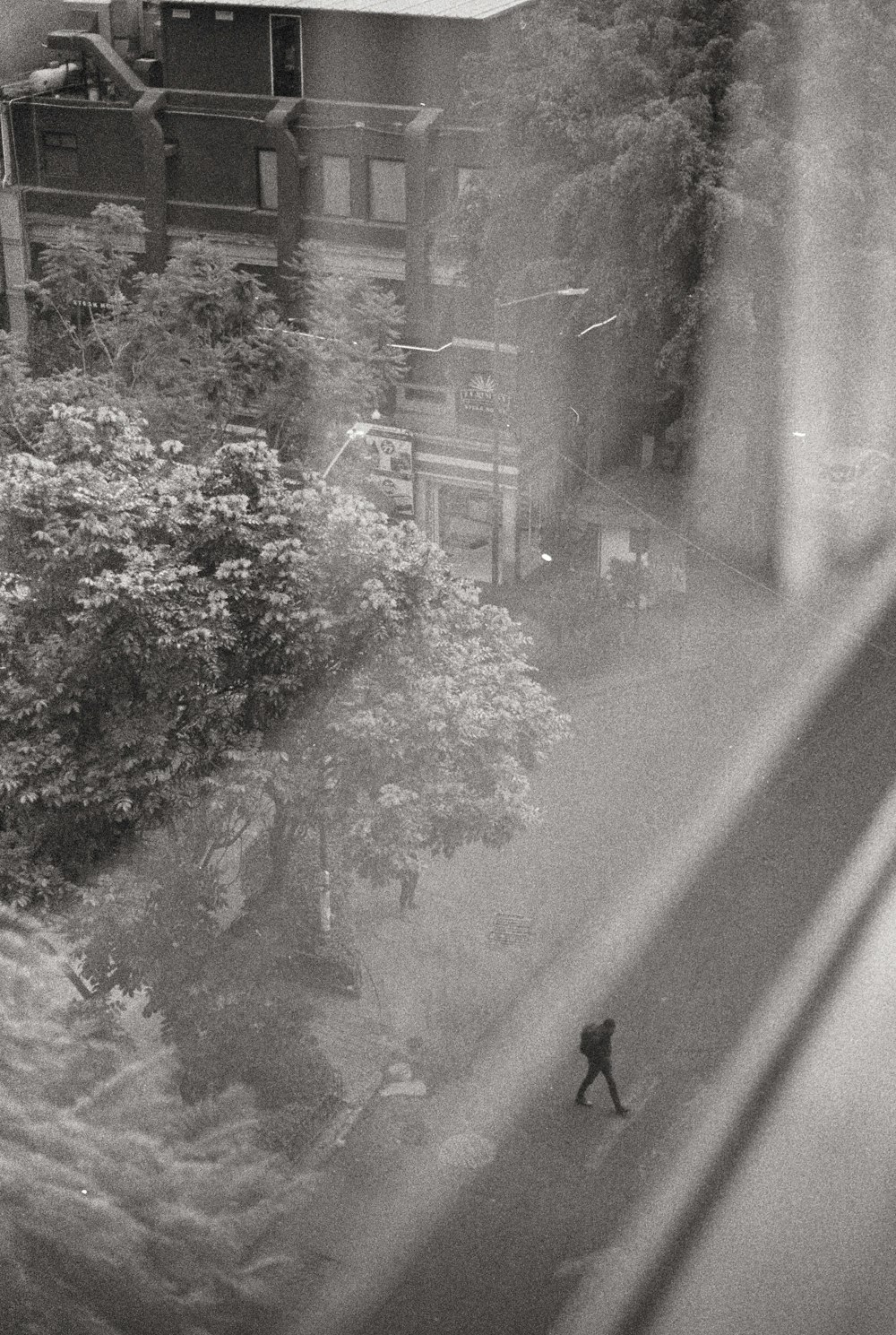 a black and white photo of a person walking down a street