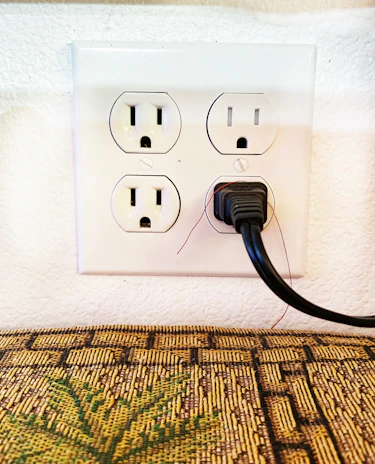 Electrician replacing a burnt-out electrical outlet in a modern Taguatinga Sul apartment.
