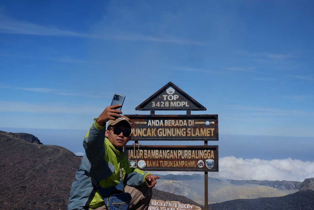 Un homme prenant un selfie au sommet d’une montagne